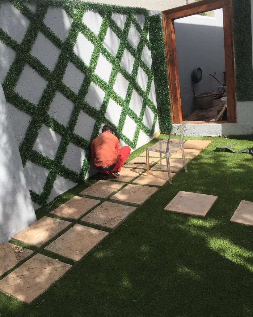 Green diamond-pattern trellis wall installation on artificial turf
