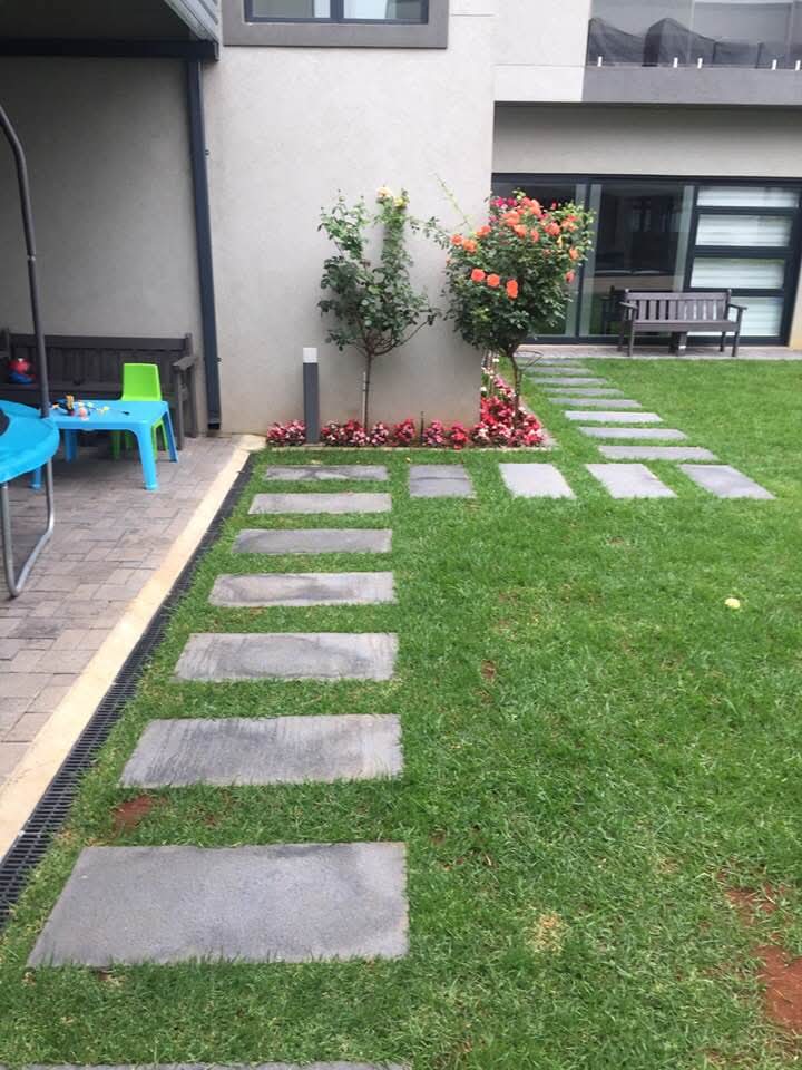 Backyard patio with stepping stones, roses and garden bench