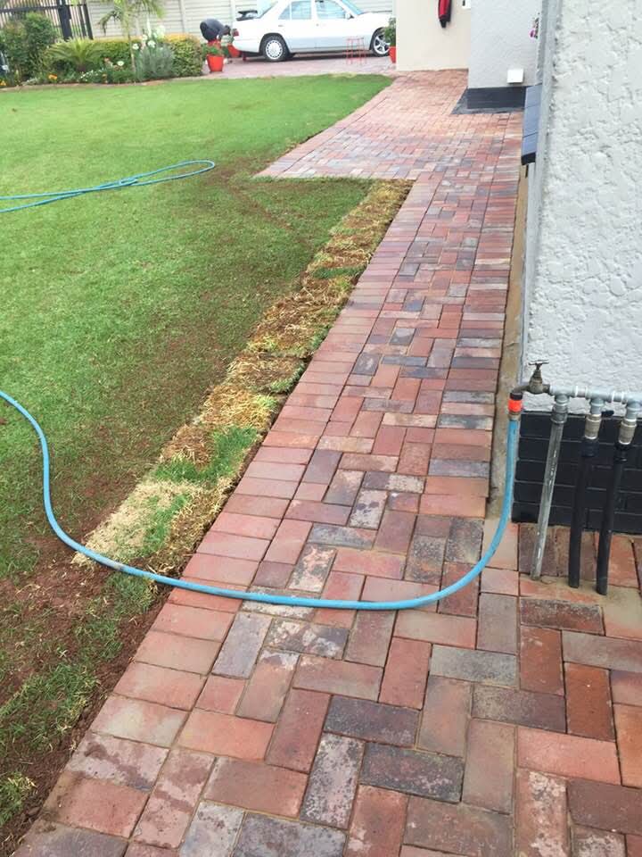 Herringbone brick walkway laid alongside a house wall