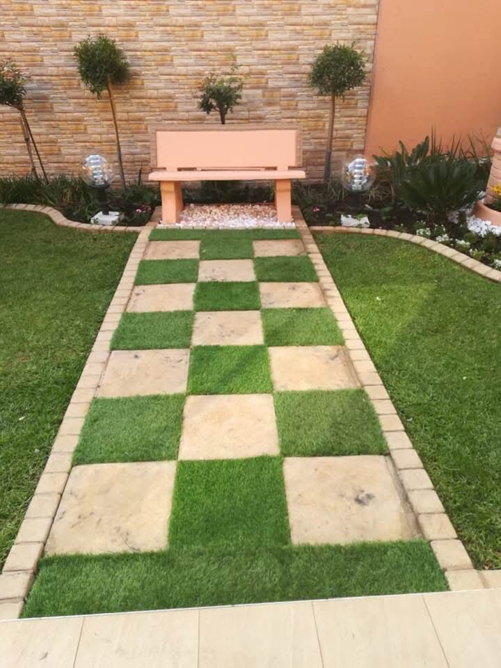 Symmetrical garden with checkerboard stone path and feature bench
